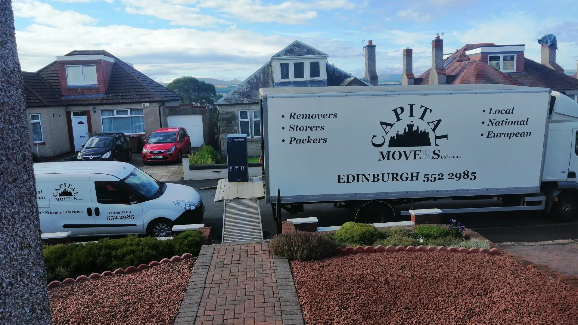 Capital Movers Edinburgh removal van with loading ramp deployed outside a residential house in a typical Edinburgh street