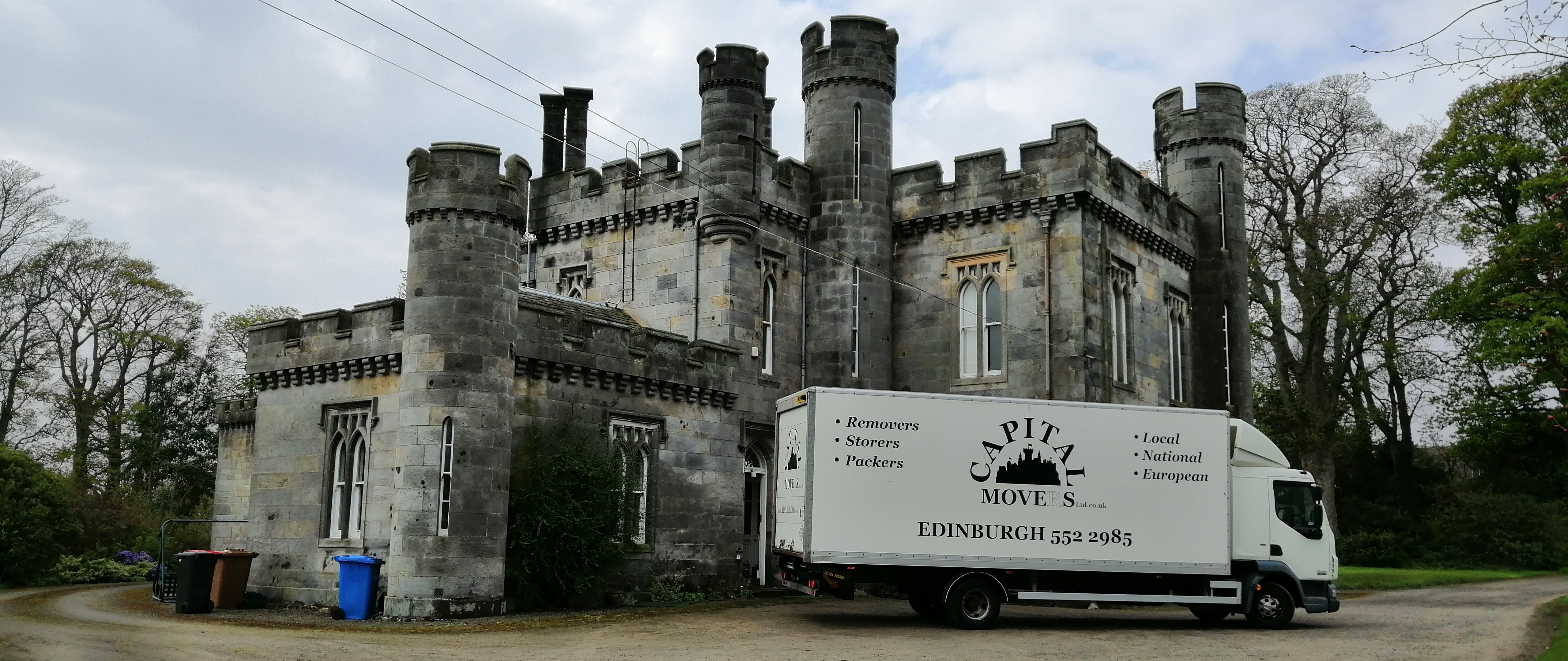 Capital Movers Edinburgh removal truck parked outside a historic Scottish castle during a multi-drop house move